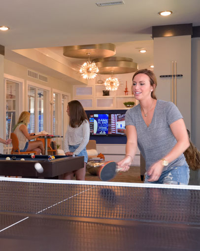 Young woman playing ping pong in lounge