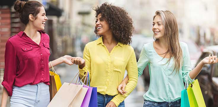 Group of women holding shopping bags and smiling